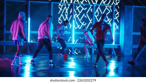 Friends Playing Soccer at a Stylish Spot with Neon Lights and Skyscrapers at Night. Young Football Player Dribbling, Showing Off Tricks and Dodging Opponents - Powered by Shutterstock