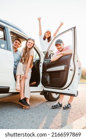 friends posing near car on sunset. road trip concept - Shutterstock ID 2166597869
