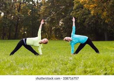 Friends Practicing Yoga Together Parkyogatrikonasana Rightright Stock ...