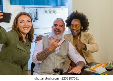 Friends prepare a vegan dinner at home and enjoy taking selfies with the smart phone, a group of multiracial people at a party in the house to celebrate an event - Shutterstock ID 2236107061
