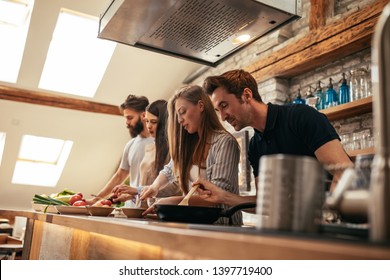 Friends preparing delicious meal at home - Powered by Shutterstock