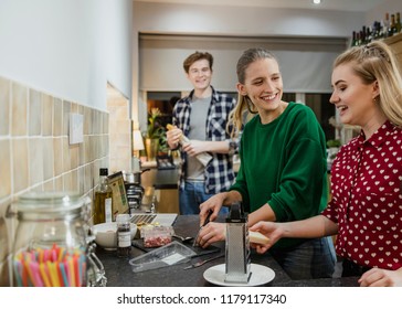 Friends Are Preparing Food For A Dinner Party At Home.