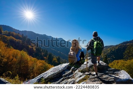 Friends relaxing on fall hiking trip. Couple on top of the mountain enjoying beautiful autumn scenery. Smoky Mountains National Park, near Gatlinburg, Tennessee, USA