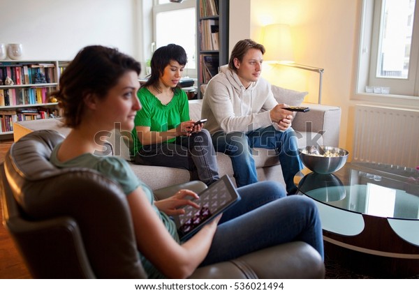 Friends relaxing\
together in living room