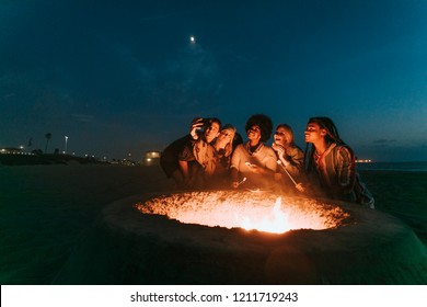 Friends Roasting Marshmallows Over A Bonfire