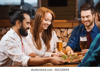 Friends Sharing Pizza With Beer At Pizzeria