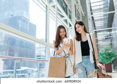 Friends Shopping Together And Using Mobile Phone