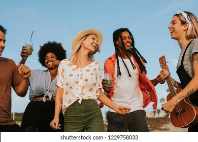 Friends singing and dancing at the beach - Powered by Shutterstock