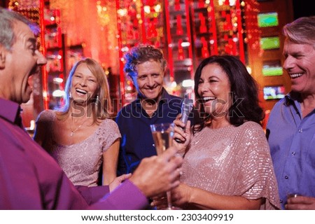 Friends singing karaoke in nightclub