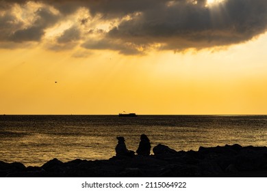 Friends Sitting Down Against The Beatiful Sunset