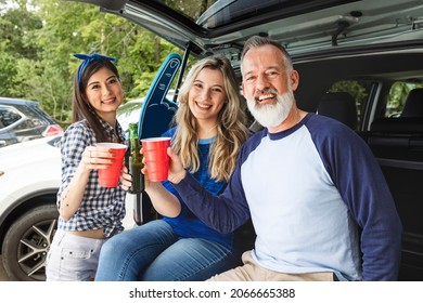 Friends Sitting And Drinking In The Car Boot At A Tailgate Party