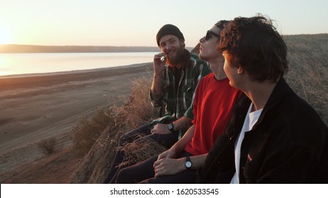 Friends Skateboarders Smoking Joint With Weed At Seashore At Sunset