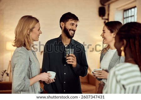 Friends smiling and talking while casually enjoying beverages together in a cozy setting.