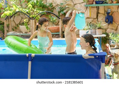 Friends Splashing Happily In A Backyard Swimming Pool.