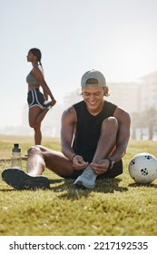 Friends, Sport And Fitness, Stretching On Grass With Soccer Ball, Warm Up For Exercise And Workout Outdoor In Park. Young Man Tying Shoe Lace, Black Woman And Sports Training With Body Wellness.