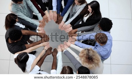 Friends with stack of hands showing unity and teamwork.
