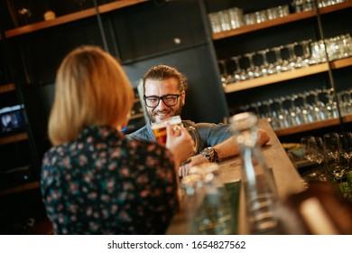 Friends standing in bar and toasting with beer. - Shutterstock ID 1654827562