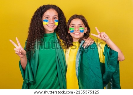 friends supporters from Brazil, football fans, making a symbol of peace and love with their fingers, pose for a photo. World Cup. Olympics.