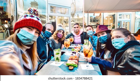 Friends Taking Selfie Outside At Cocktail Bar - New Normal Lifestyle Concept With Young People Having Fun Together At Restaurant Cafe Covered By Face Masks - Vivid Filter With Focus On Central Guy 