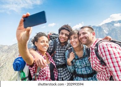 Friends Taking Selfie At Top Of Mountain