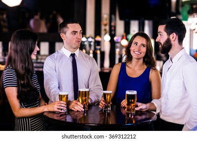 Friends talking and having a beer in a bar