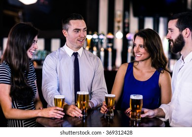 Friends talking and having a beer in a bar