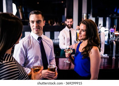 Friends talking and having a drink in a bar