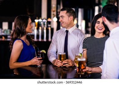 Friends talking and having a drink in a bar