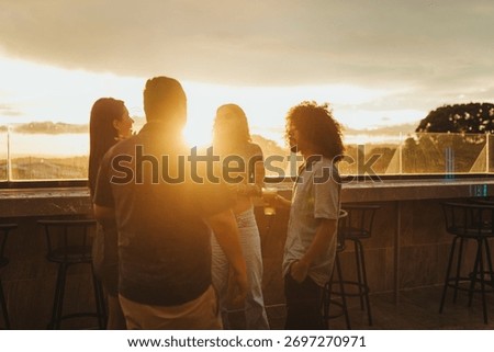 Friends talking at rooftop bar during golden hour