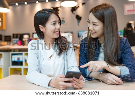 Friends talking together with cellphone 