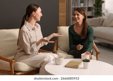 Friends talking while having tea at home