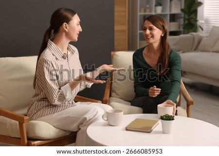Friends talking while having tea at home