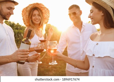 Friends tasting red wine in vineyard on sunny day - Powered by Shutterstock