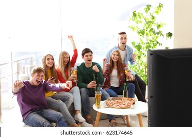 Friends With Tasty Pizza And Beer Watching Sports On TV At Home