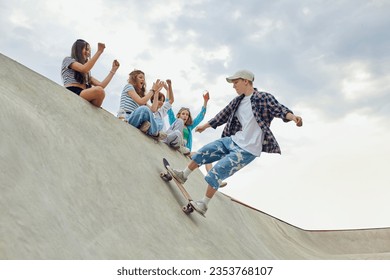 Friends, teengaers meeting at skate park for active leisure time. Boy in casucl clothes skateboarding on ramp. Concept of youth culture, sport, dynamic, extreme, hobby, action and motions, friendship - Shutterstock ID 2353768107