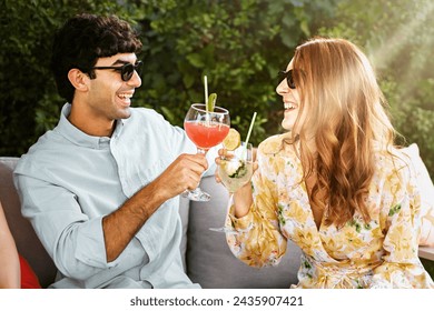 Friends toast with summer cocktails in a garden - Joyful atmosphere as they enjoy refreshing drinks, sharing a sunny moment together. - Powered by Shutterstock