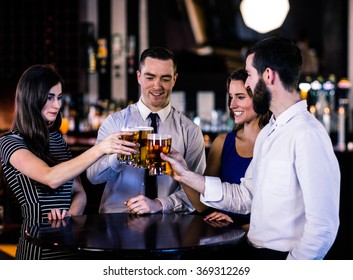 Friends toasting with a beer in a bar