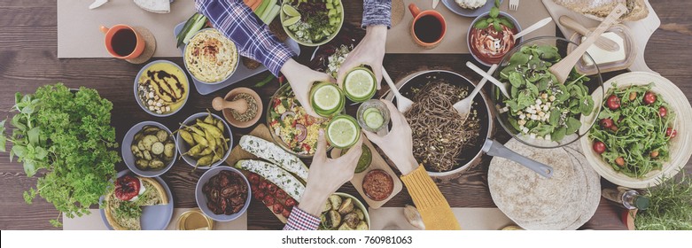 Friends Toasting And Celebrating Their Meeting With A Healthy Vegan Meal