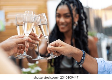 Friends Toasting Champagne with Smiling African-American Woman - Champagne flutes toast in restaurant courtyard, woman joins.