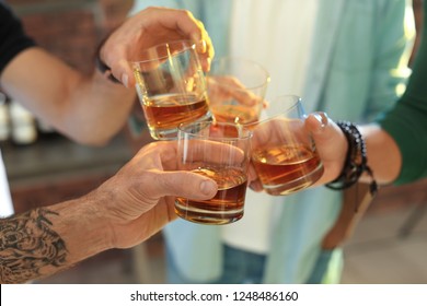 Friends Toasting With Glasses Of Whiskey Indoors, Closeup