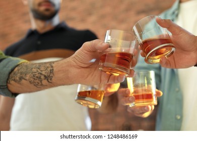 Friends Toasting With Glasses Of Whiskey Indoors, Closeup