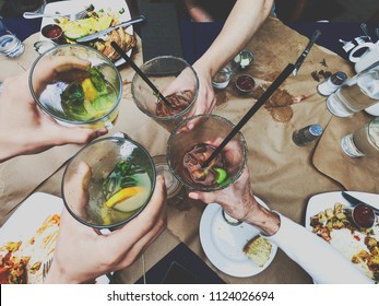 Friends Toasting With Margaritas And Bloody Mary Cocktails During Brunch