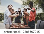 Friends Toasting with Red Wine - Mixed-age group, including two men and a woman in their 40s, a young plus-size person, and a 25-year-old African person, toasting wine glasses, looking at the camera.