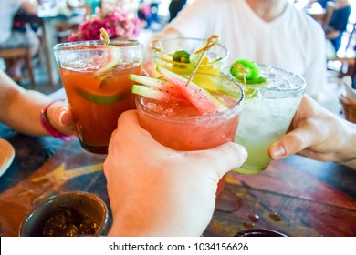 Friends Toasting, Saying Cheers Holding Tropical Blended Fruit Drinks