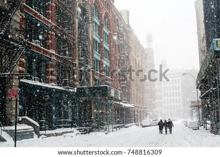 Friends travel down a New York City street in a blizzard