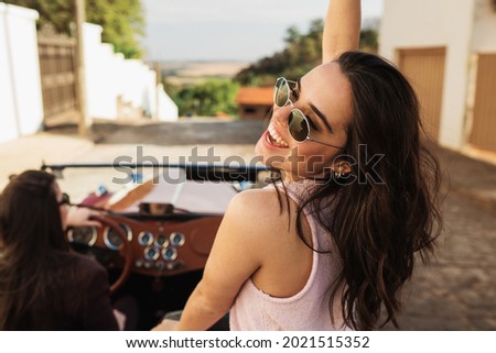 Friends traveling together in an old convertible car. Summer enjoyment concept