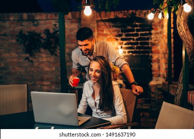 Friends Using Laptop At Home Backyard, Night Scene