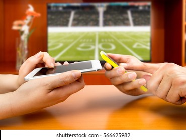 Friends Using Mobile Phone And Betting During A American Football  Match