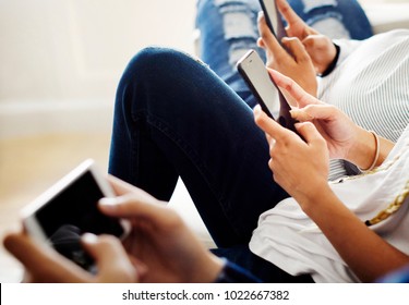 Friends using smartphone together at home - Shutterstock ID 1022667382