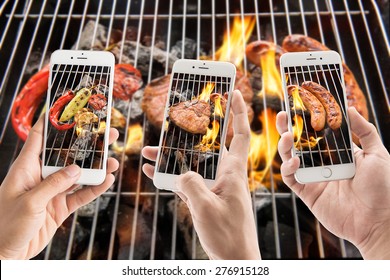 friends using smartphones to take photos of sausage and pork chop and vegetables on the flaming grill. - Powered by Shutterstock